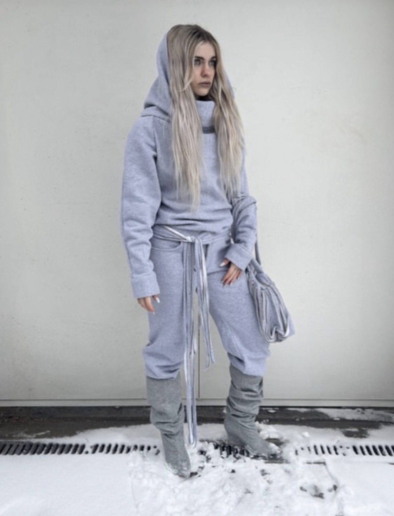 Grey hooded set, photographed against concrete